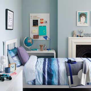 blue bedroom with white wooden bed, fireplace and desk