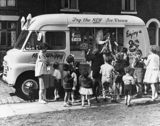Children gather round a Mr Whippy ice cream van.