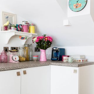 Kitchen area with white wall and ceramic worktop