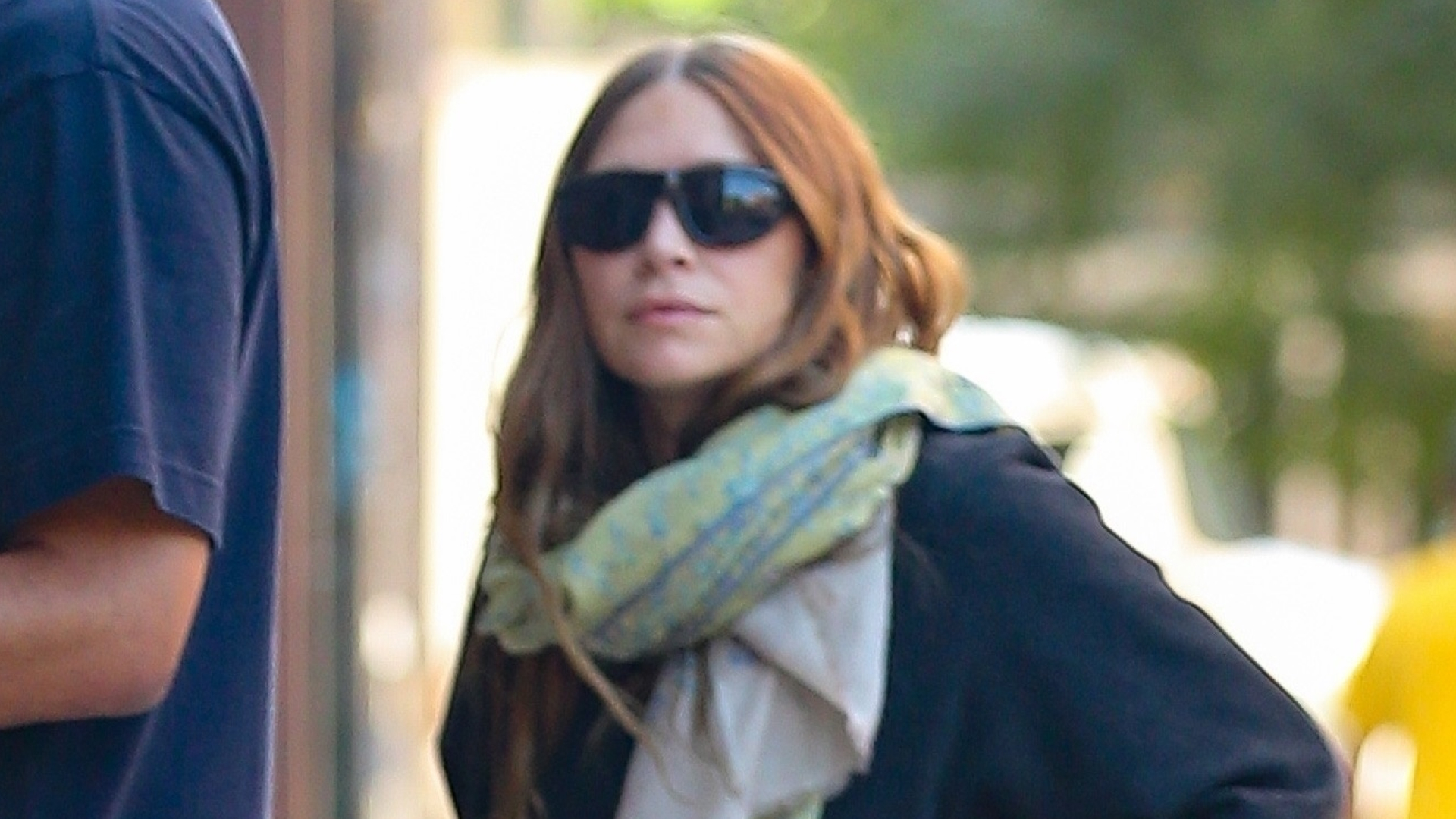 Ashley Olsen wearing jeans, slides, and carrying a rare alligator The Row bag