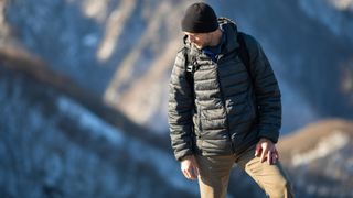 best down jacket: man hiking with down jacket