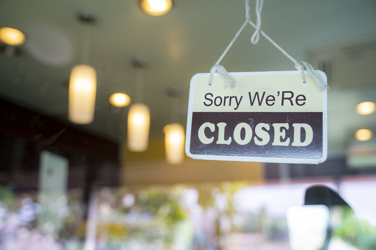 Closed sign hanging on glass door in small business window.