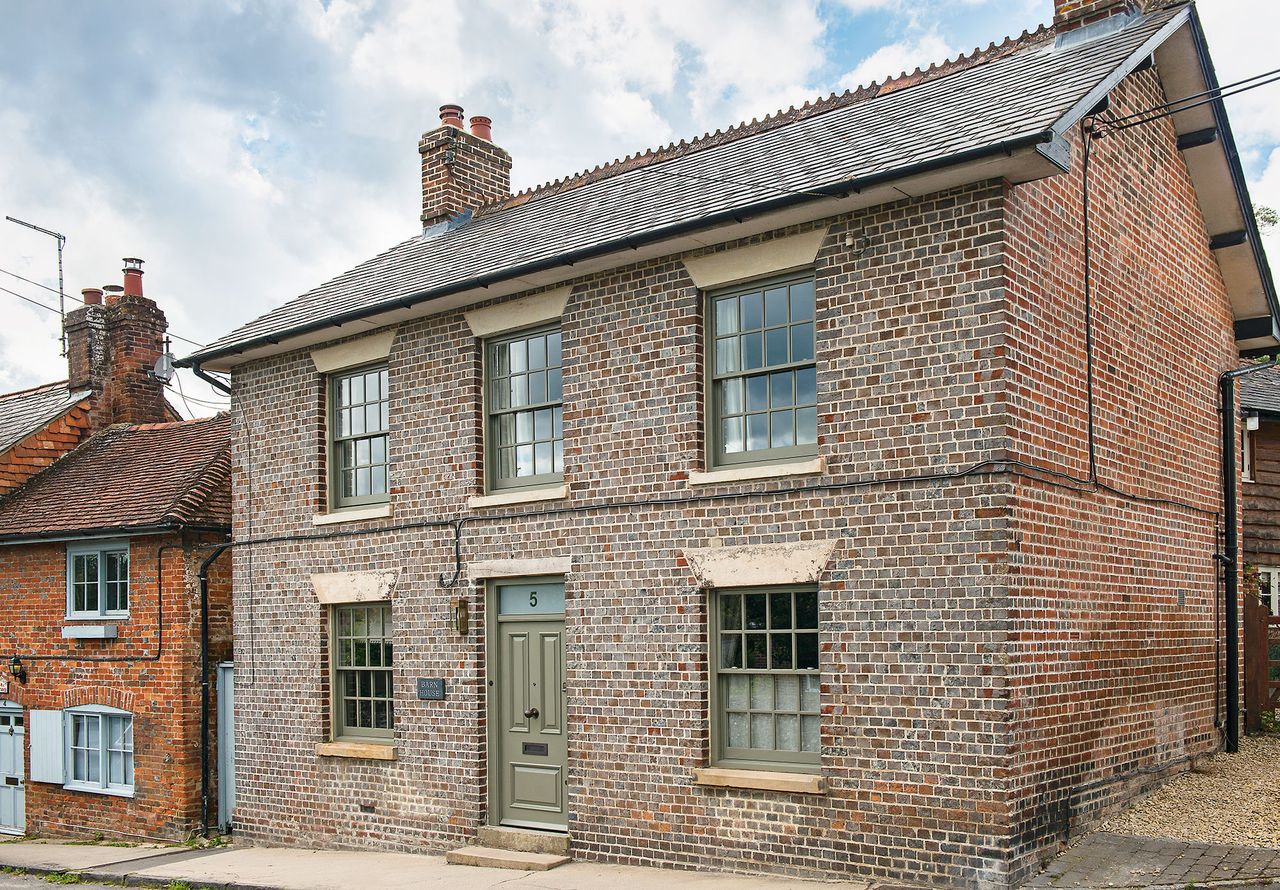 exterior of double fronted Georgian home with pale green painted window frames and door