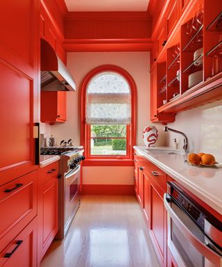 bright orange kitchen with arched window