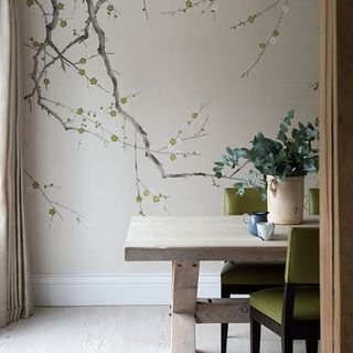 dinning room with white wall and floral painting wooden dinning table with green chairs