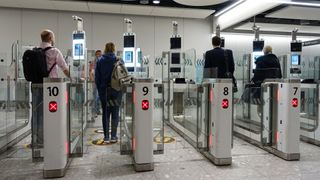 Air travellers pass through automated passport border control gates at Heathrow Airport, where the UK Border Force uses facial recognition technology.