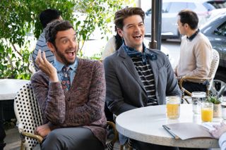 Michael Urie and Devin Kawaoka, sitting at a table at an outdoor cafe, in 'Shrinking' season 2.