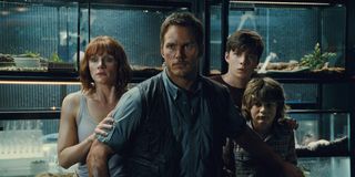 Owen Grady stands in front of Claire, Zach and Gray in a scene from Jurassic World