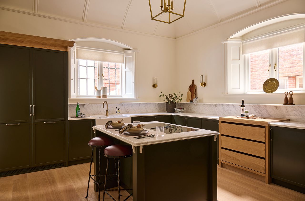 Black-painted panelled cabinetry contrast with deeply veined marble worksurfaces in the barrel-vaulted kitchen of the first-floor apartment