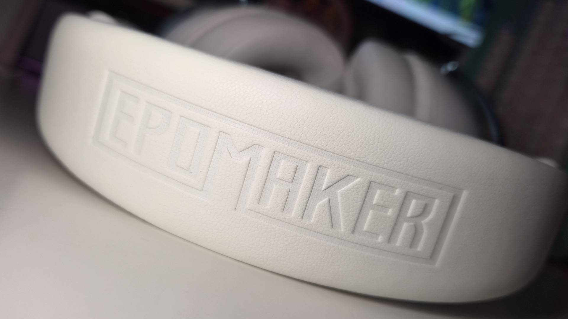 Photo of the Epomaker GX1 headset sitting on a white desk.