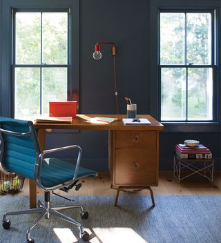Modern home office ideas with dark blue walls and wooden desk