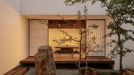 A home with an engawa, paper screens, a gravel garden, and a rock