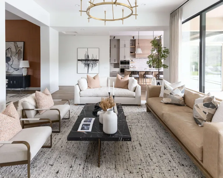 Modern living room with white couches, angular coffee table and geometric pendant lighting