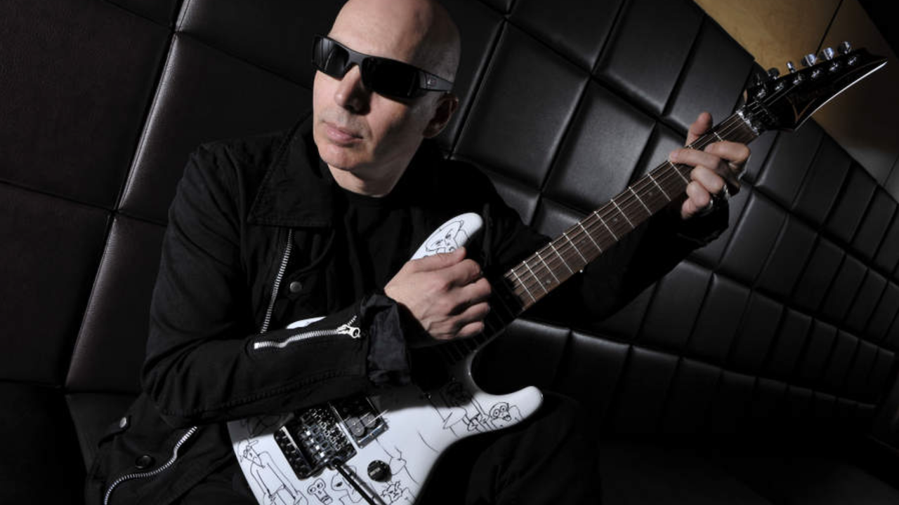 Joe Satriani posing with a guitar