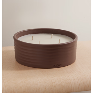 large scented candle in a brown ceramic jar