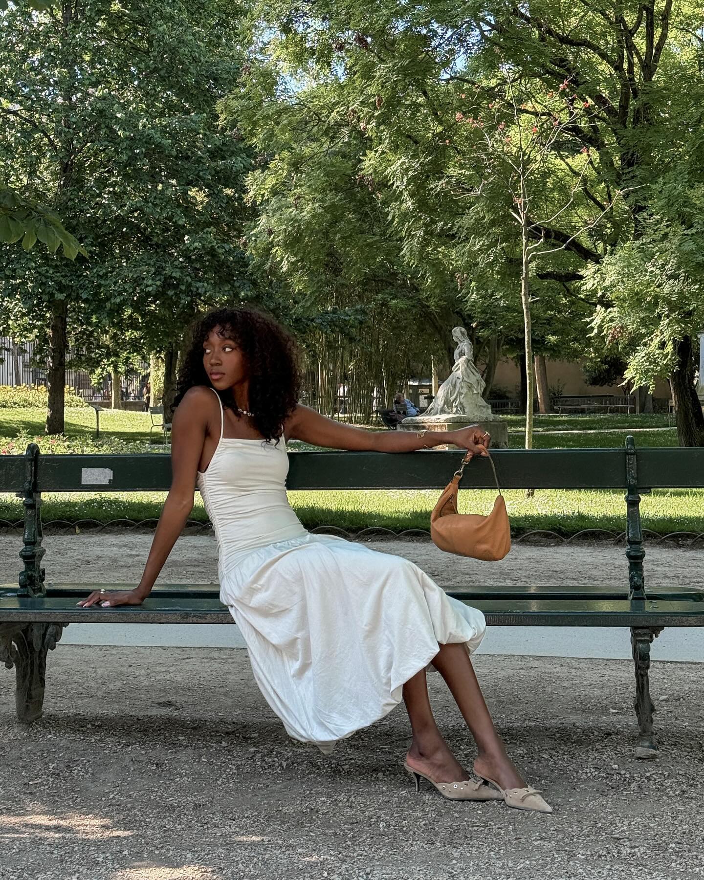 Woman in white dress sitting on bench