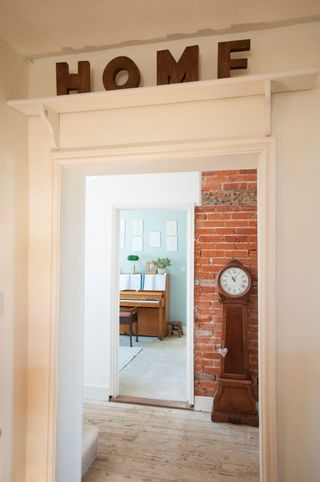 A glimpse into a music room from a hallway with a bare brick wall