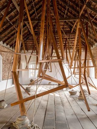 A wooden large-scale installation transforms an attic into a labyrinth.