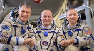 Expedition 52 flight engineers Paolo Nespoli of the European Space Agency, left; Sergey Ryazanskiy of Roscosmos; and Randy Bresnik of NASA pose for a photograph outside the Soyuz simulator.
