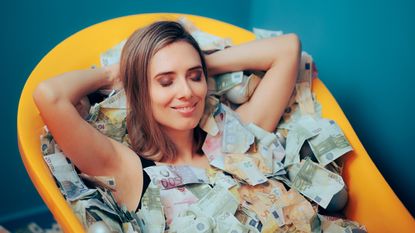 A smiling woman relaxes in a bathtub full of cash.