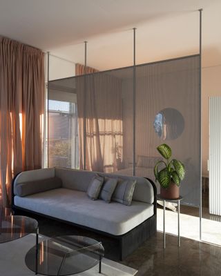Sheer curtains and perforated room divider in the private home