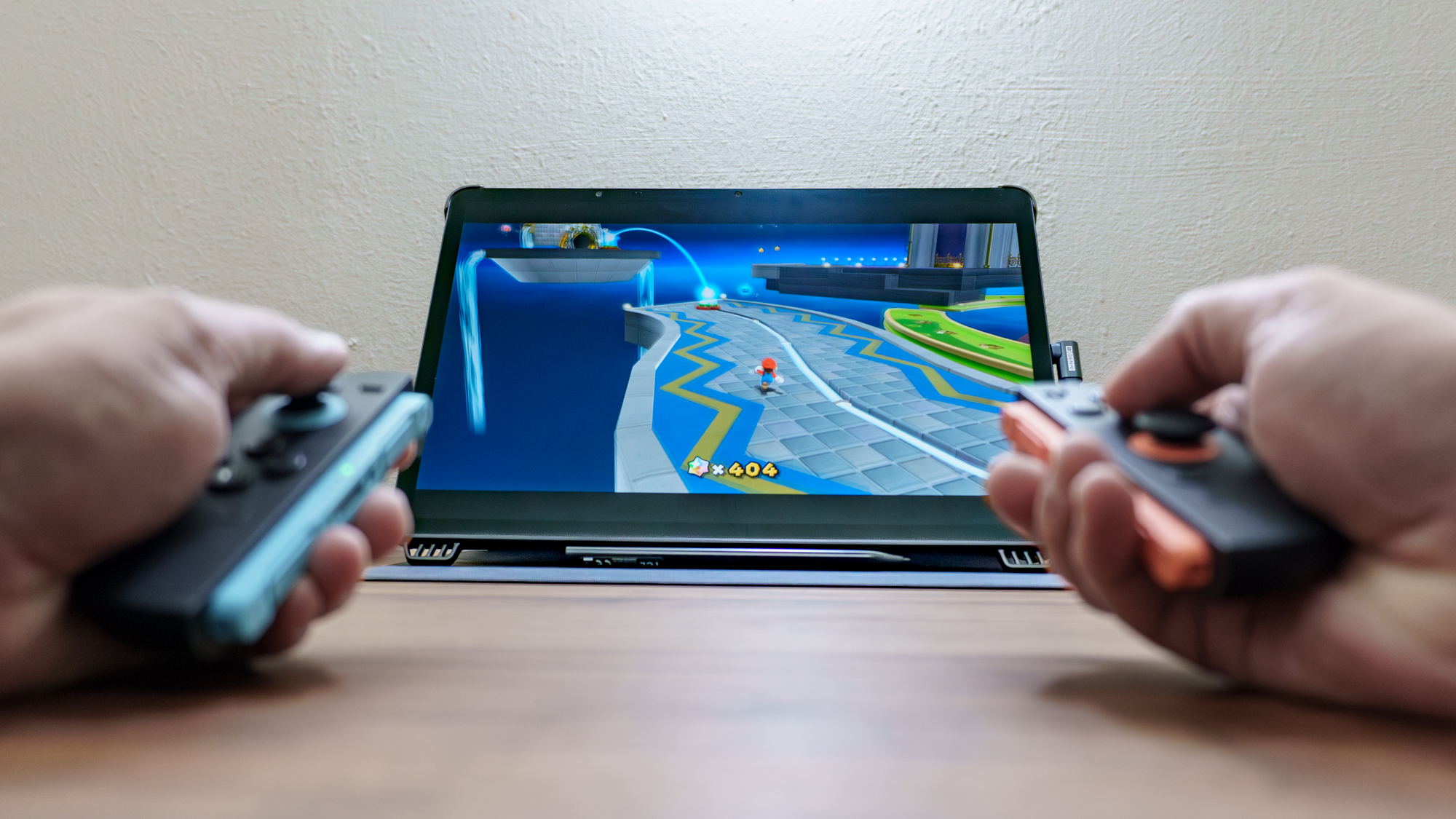 A person playing Super Mario Galaxy on the Nintendo Switch 2 on the TCL NXTPAPER 14 using the Genki Covert Dock 3 and the Genki ShadowCast 3 Pro