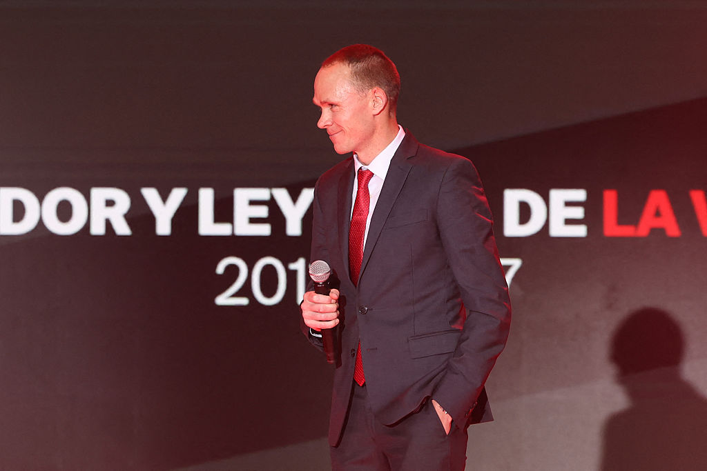 Chris Froome stands on stage holding mic