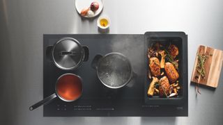 induction hob with pans and food cooking