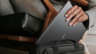 Dell Pro laptop being placed inside a bag, with plenty of room to fit