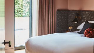 pink master bedroom with upholstered headboard