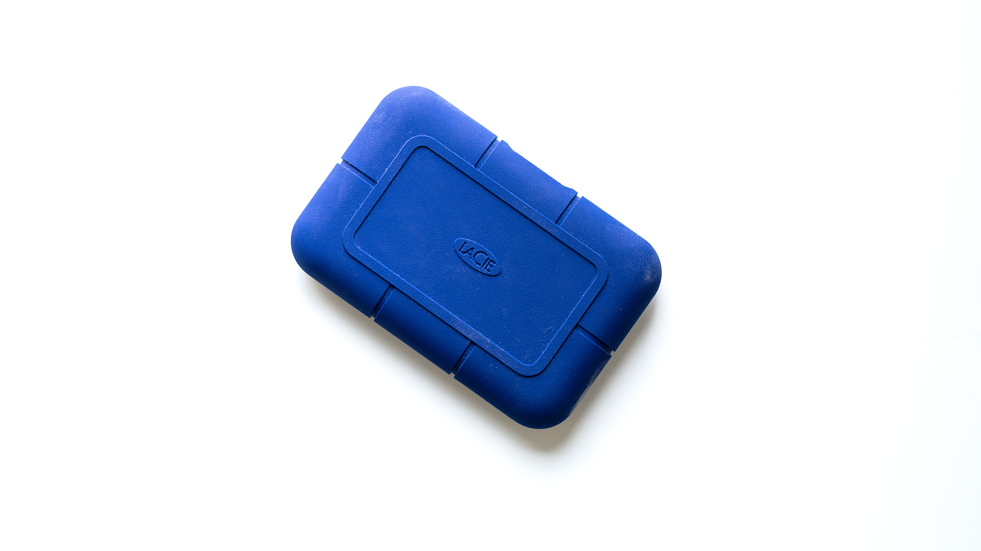 The LaCie Rugged Pro 5 in blue on a laptop and on a white background.