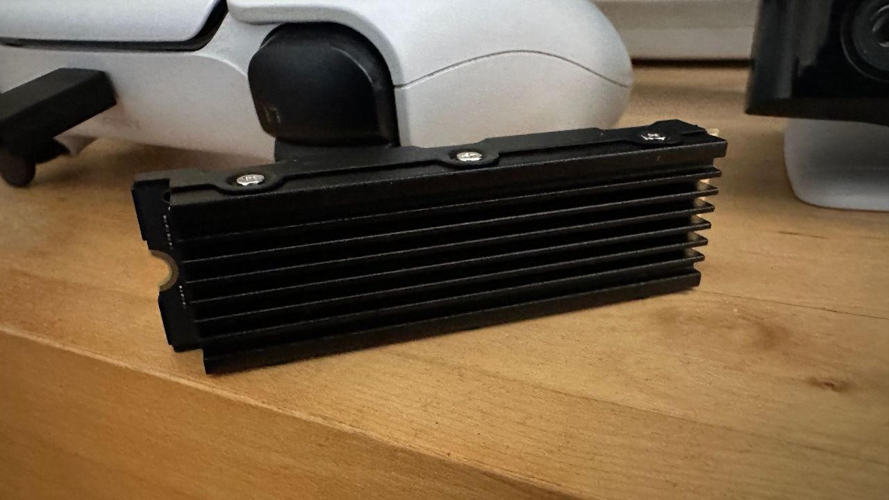 Nextorage NEM-PA Series SSD sitting on its side next to a DualSense controller