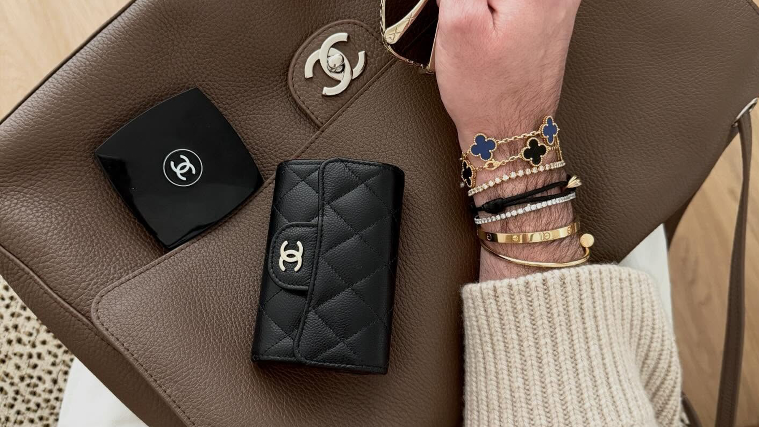 Who What Wear editor Bobby Schuessler poses with his Chanel classic flap wallet, one of the best designer luxury wallets on the market.