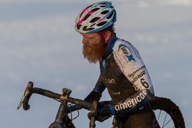 Robert Marion runs his bike through the mud