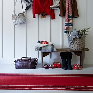 white hallway with red carpet and basket