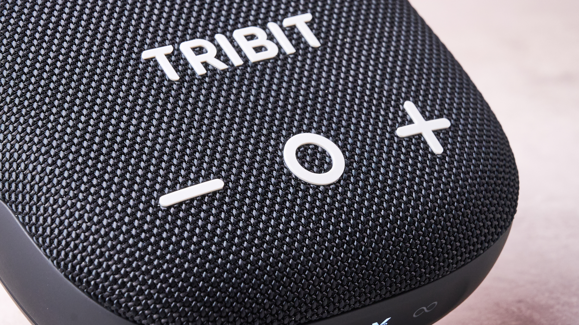 A closeup of the play and volume buttons on the front of the Tribit Stormbox Micro 3.