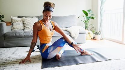 Wrist pain in yoga: Images shoes smiling woman stretching after working out in living room of home
