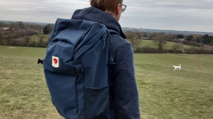 Side view of fitness writer Lily Canter wearing the Fjallraven Ulvo backpack outside