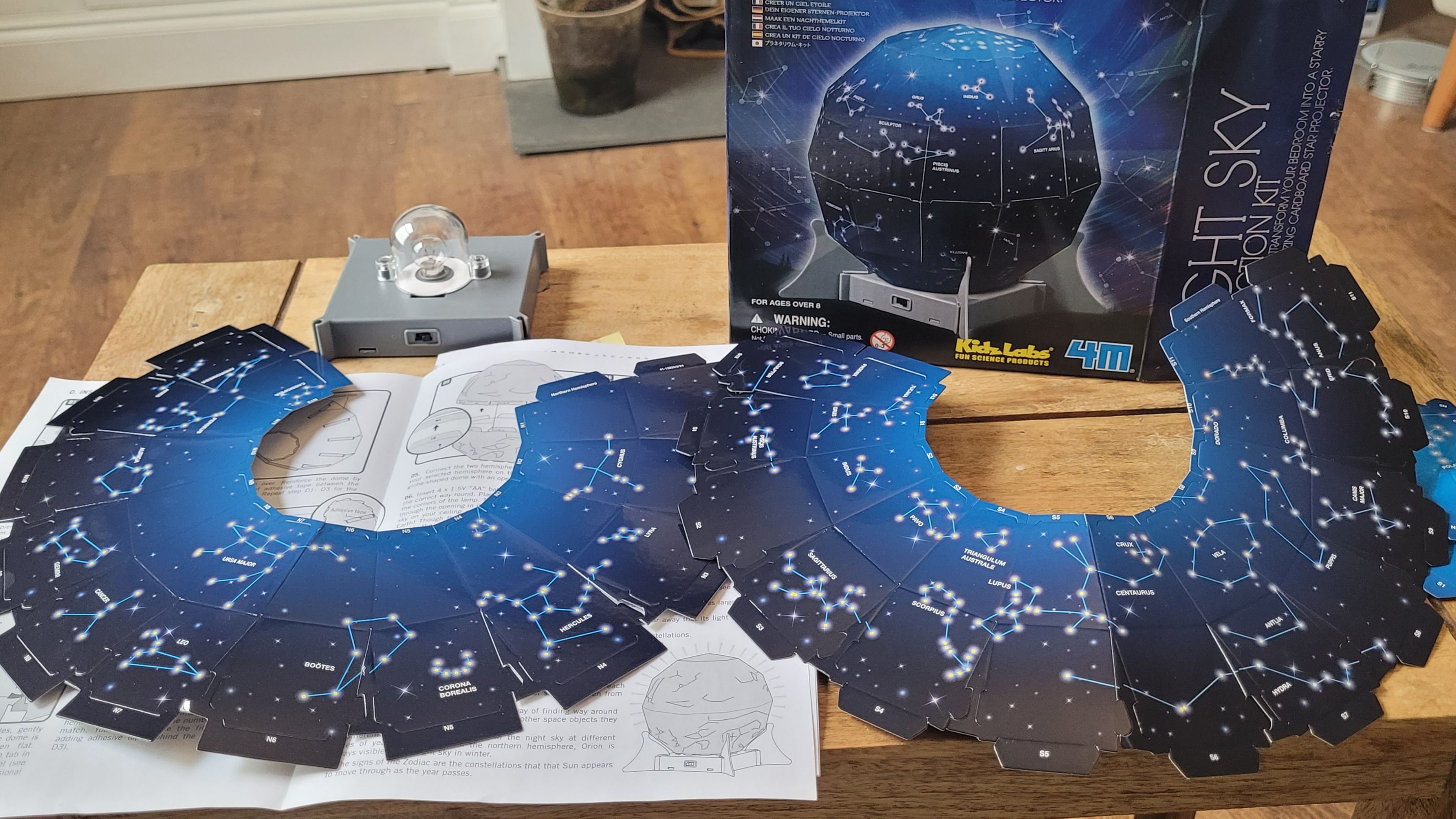 The contents of the Create A Night Sky Kit is displayed on a wooden table
