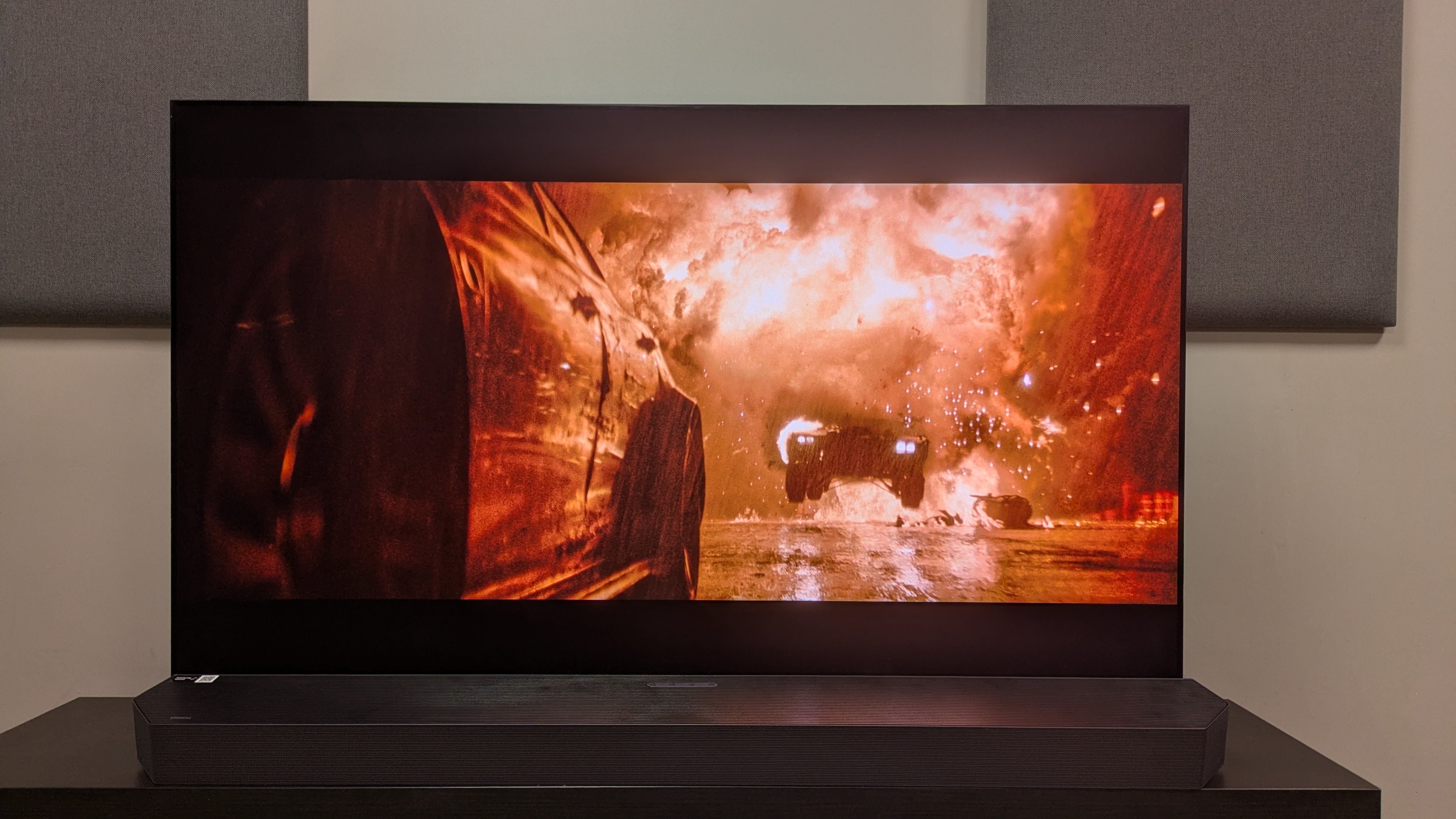 Samsung HW-Q990H connected to Samsung S95F OLED TV showing the batman on screen, with the batmobile driving through fire