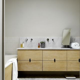 bathroom with white wall brown cabinet bathtub with towel
