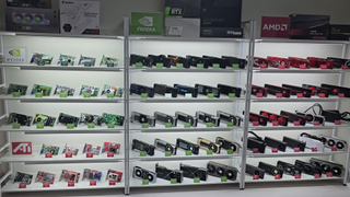 A collection of GPUs, well-lit and carefully lined up along multiple shelving units.