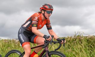 Jo Tindley riding a bike with a field behind her