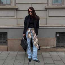 @annabelrosendahl outfit photo black blazer with blue jeans and plaid shirt around waist