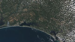 The white sands of Pensacola Beach stand out in this Landsat 9 image of the Florida Panhandle of the United States, with Panama City visible under some popcorn-like clouds. Landsat and other remote sensing satellites help to track changes to US coastlines, including urban development and potential impacts of rising sea levels.