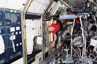 STS-40 payload specialist Millie Hughes-Fulford flies through the Spacelab module in space shuttle Columbia's payload bay in June 1991.