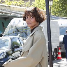 Halle Berry wearing a tan trench coat and black pants