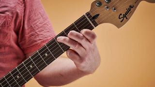 Close-up of guitarist playing C major chord on electric guitar