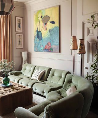 Pink living room with pale velvet green sofa