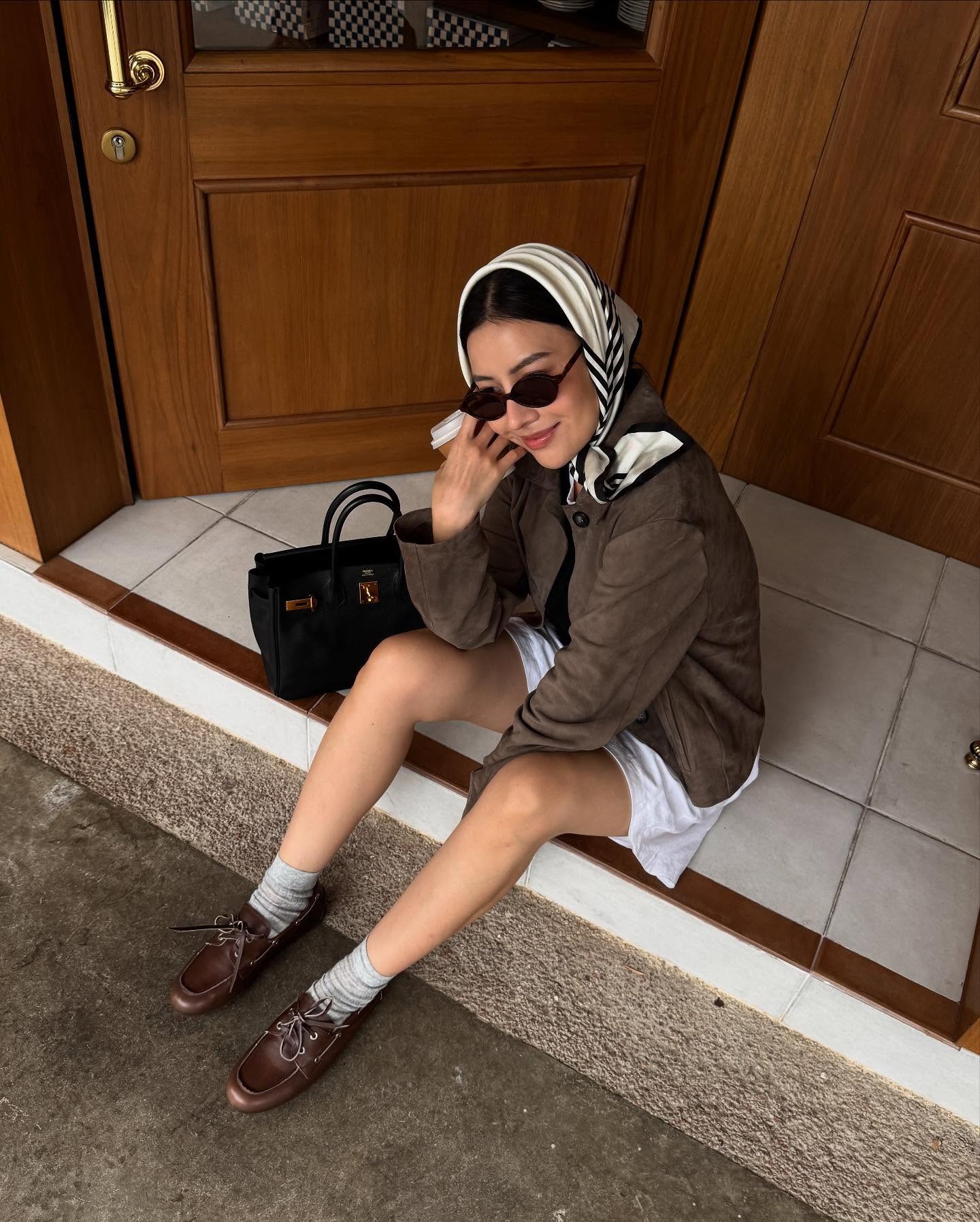 Fashion person Savina Chow wears a brown shoe outfit. She pairs her brown shoes with a brown suede jacket, white short and a black and white headscarf in a recent image taken from her Instagram.